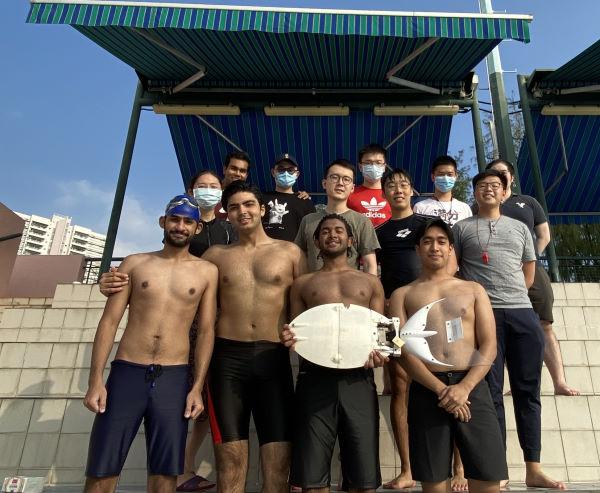 Group photo of students holding a robotic fish on the side of Henry Fok Swimming Pool