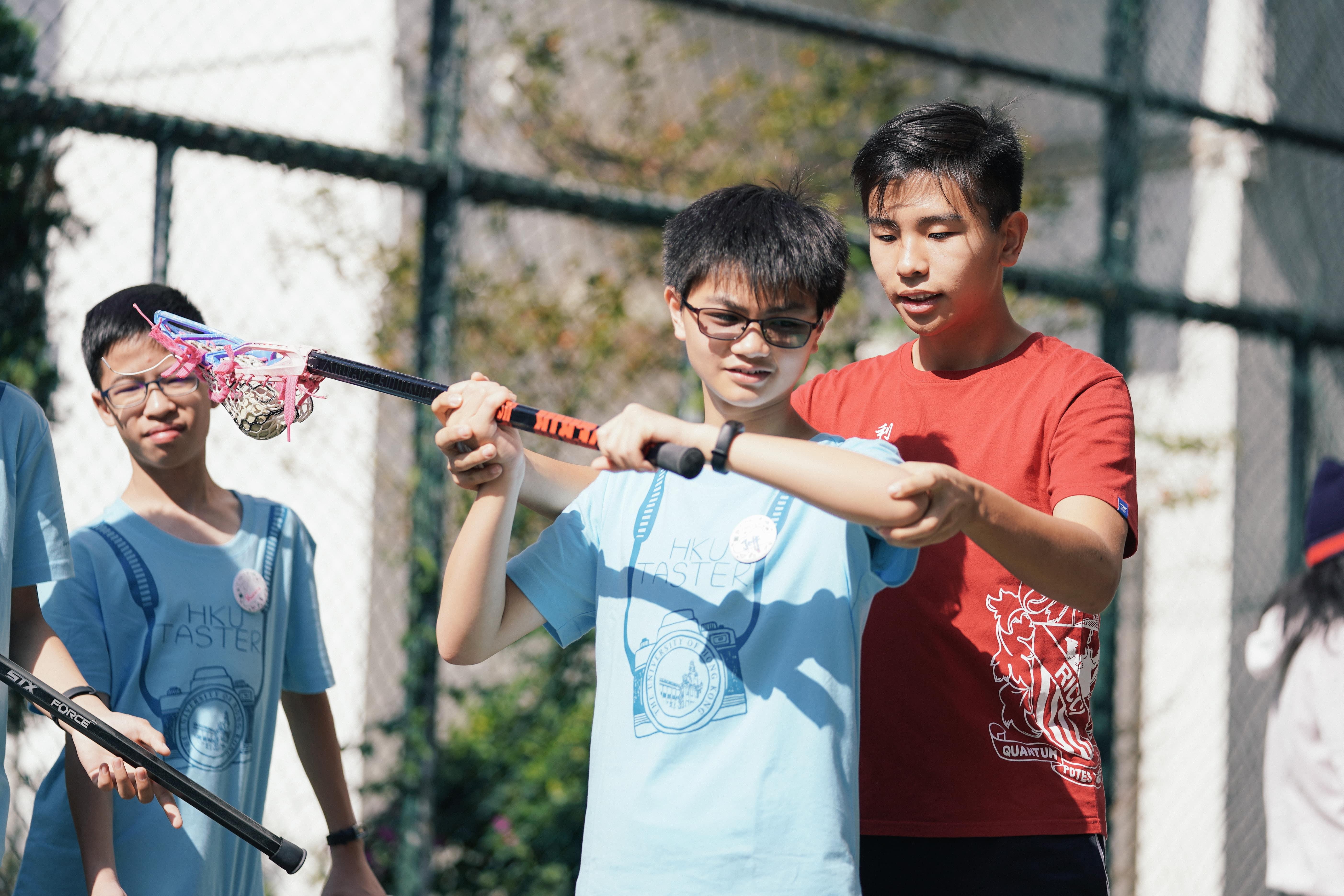 學生們正在學習如何玩長曲棍球