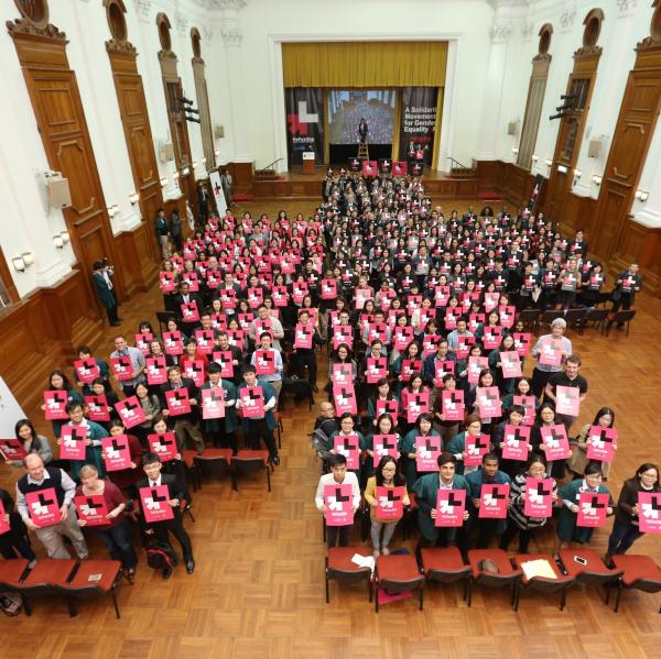Room of students holding a He for she poster