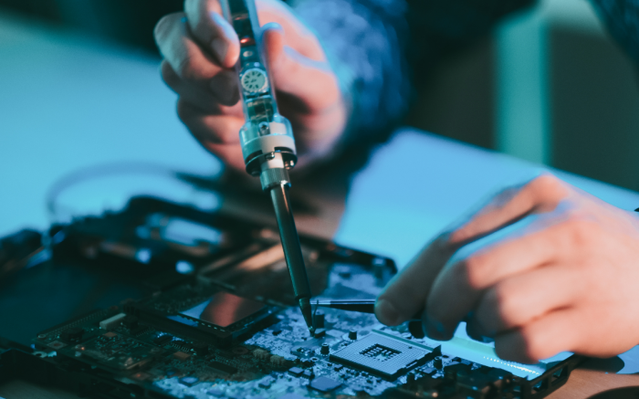 Technician soldering a motherboard