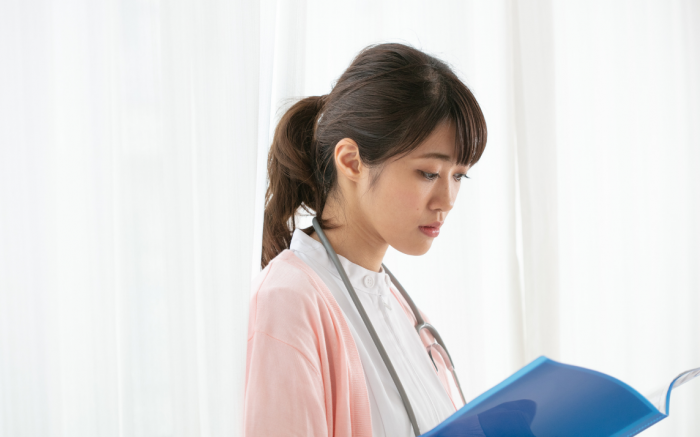 Female nurse looking at a book