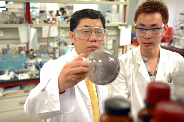 2 people in labcoat holding an equipment