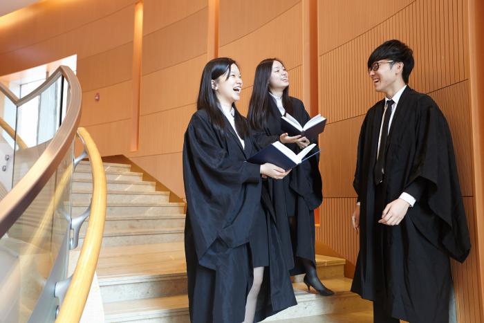 Students conversing, wearing formal attire