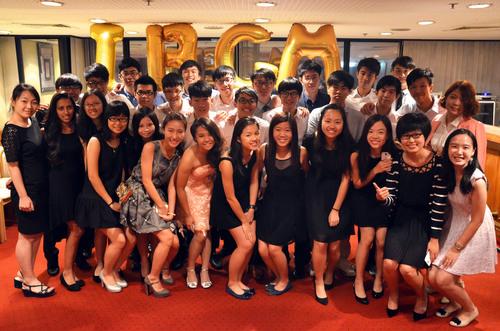Group of students in smart casual attire posing in front of IBGM balloons