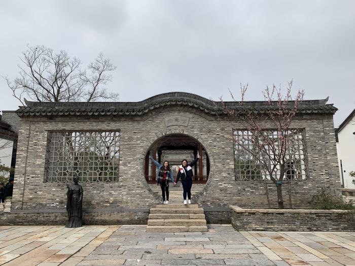 Students posing in front of a Chinese architecture