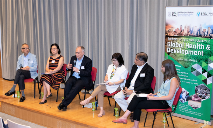 Guests speaking on stage with a Global Health and Development banner in the background