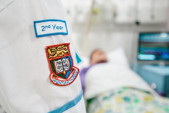 Zoom in on student's nurse uniform with HKU crest and a "2nd year" badge