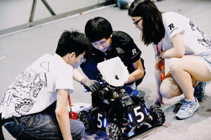 Students working on robot in a competition
