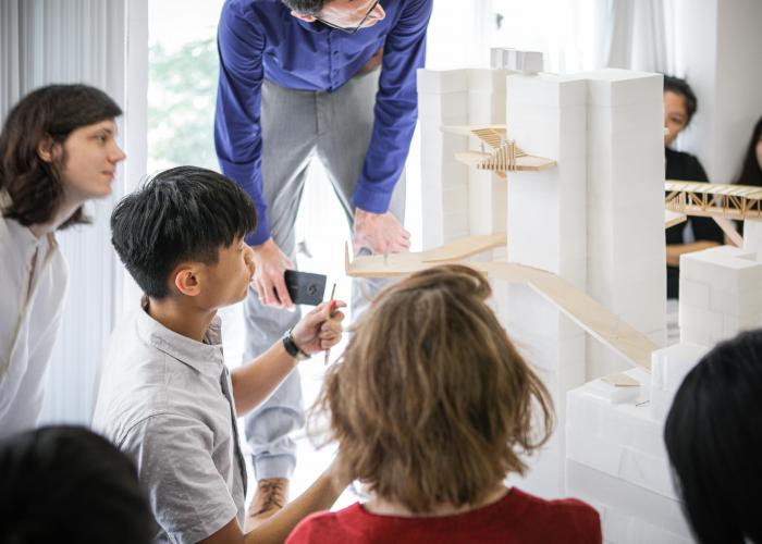 People gathering around architecture models