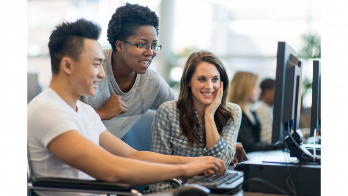 Three college students are looking at a computer 