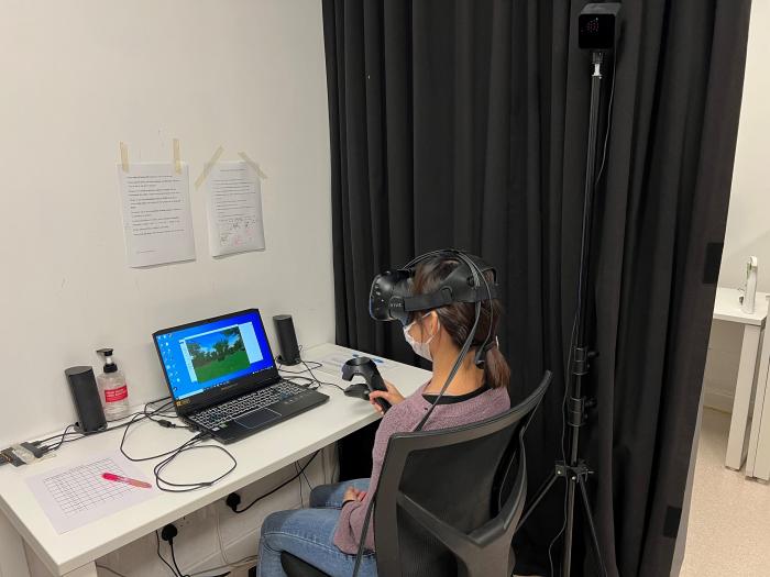 Student wearing a VR headset sitting in front of a laptop