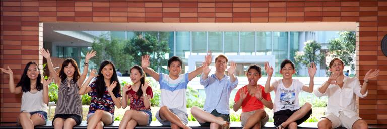 一群学生在志华学习大楼前挥手致意