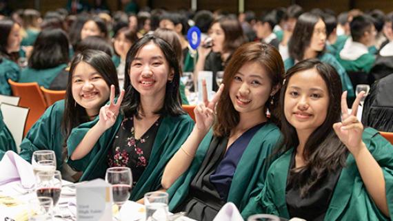 Students smiling at a high table event
