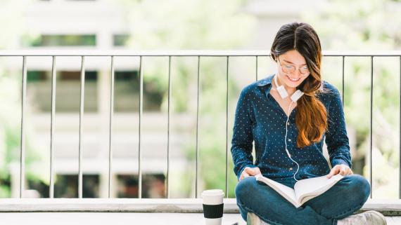 Female student reading a book on campus