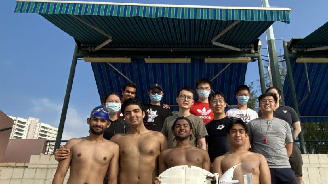 Group photo of students holding a robotic fish on the side of Henry Fok Swimming Pool